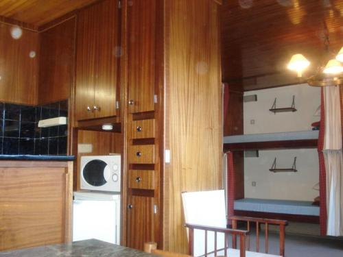 - une cuisine avec des placards en bois, une table et un four micro-ondes dans l'établissement Studio Courchevel Moriond, 26 m², 2 pers, centre station - FR-1-514-76, à Courchevel