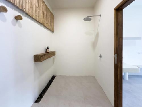 a room with a white wall and a hallway at El Tropico Boutique Hotel in Kuta Lombok