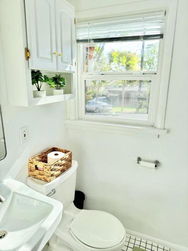 a white bathroom with a toilet and a window at Entire Private Guest Suit - UC Berkeley, SF in El Cerrito
