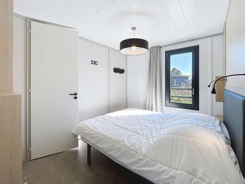 une chambre blanche avec un lit et une fenêtre dans l'établissement Chalet de Standing avec Piscine Chauffée, à 300m de la Plage - 6 Couchages, WiFi Gratuit - FR-1-361-474, à Jullouville
