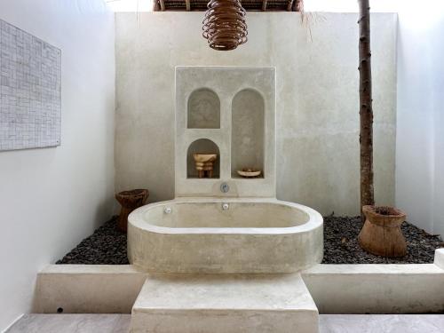 a bathroom with a large tub in a room at El Tropico Boutique Hotel in Kuta Lombok