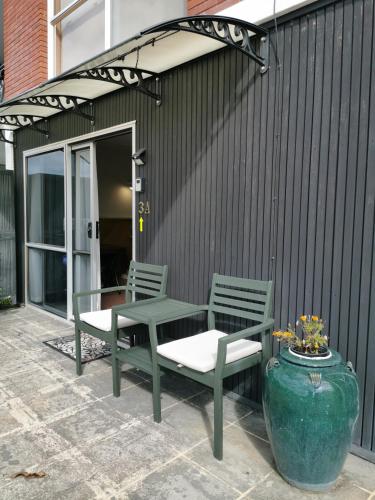 a patio with two chairs and a table and a vase at Spacious 2 bedroom apartment in Whangarei
