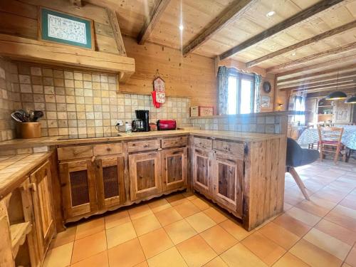 une cuisine avec des armoires en bois et un comptoir dans l'établissement Chalet à Flumet pour 8 pers avec terrasse et WiFi inclus - FR-1-505-225, à Flumet