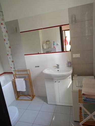 a white bathroom with a sink and a mirror at Dom Wakacyjny Wojnówko in Wojnówko