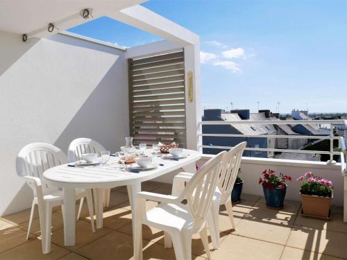 une table blanche et des chaises sur un balcon dans l'établissement Étel - Appart. 3 pièces, terrasse, animaux admis, parking sécurisé - FR-1-479-226, à Étel