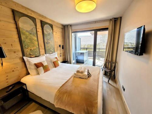 une chambre avec un grand lit et une grande fenêtre dans l'établissement Appartement spacieux au centre des Gets, 8 pers, 100m², accès direct pistes - FR-1-598-188, aux Gets