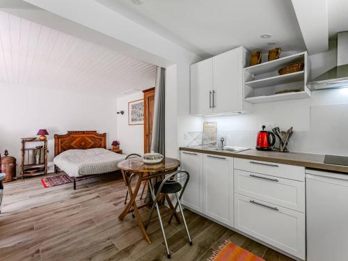 - une cuisine avec des placards blancs, une table et un lit dans l'établissement Arcachon : Dépendance Charmante à 400 m de la Plage - FR-1-433-140, à Arcachon