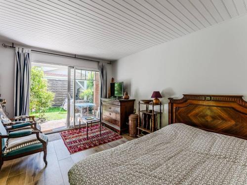 une chambre avec un lit et une porte coulissante en verre dans l'établissement Arcachon : Dépendance Charmante à 400 m de la Plage - FR-1-433-140, à Arcachon