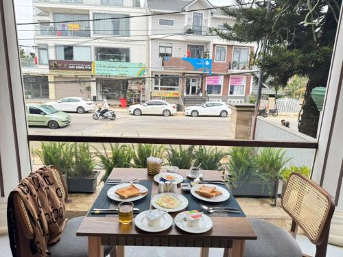 a table with plates of food on a balcony at ORCHID Hotel in Da Lat