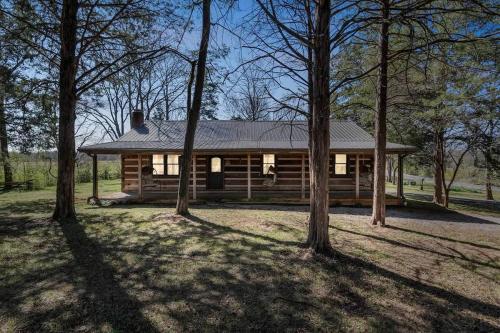 a log cabin with trees in front of it at Cozy Lux Cabin With Game Room in Murfreesboro