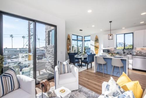 a living room with a kitchen and a dining room at Ocean View Roof Deck - Walk to the Beach & Pier in Oceanside