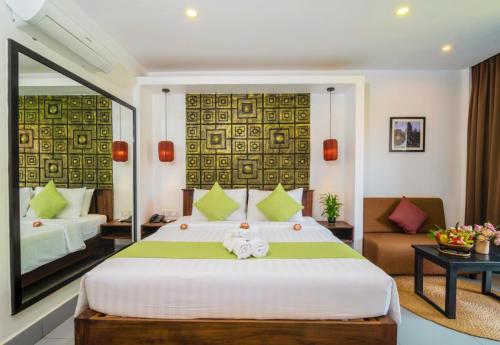 a bedroom with a large bed and a living room at Angkor Home 27 in Phumĭ Réach Born