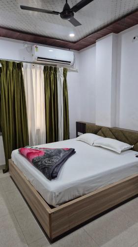 a large bed in a room with green curtains at Baba Shyam hotel in Rīngas
