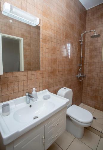 a bathroom with a sink and a toilet and a mirror at Appartement Moderne & Confortable Proche Aéroport Léon-Mba, Libreville in Libreville