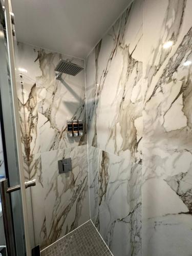 a bathroom with marble walls and a shower at The Gray Loft Escape NYC Edition. in New York