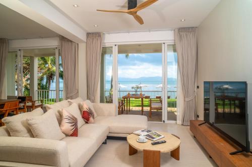 a living room with a couch and a television at Baan Bophut Beach Hotel Samui - SHA Extra Plus in Bophut
