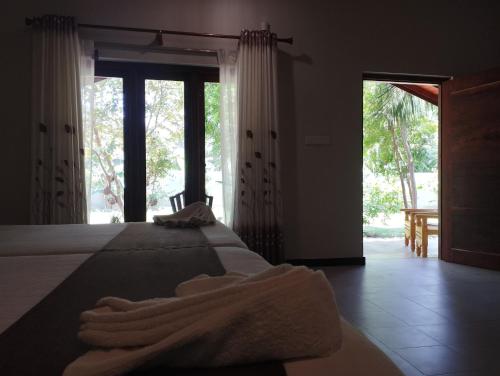 a bedroom with a bed with towels on it at The Dream Inn Guesthouse Passikudah in Batticaloa