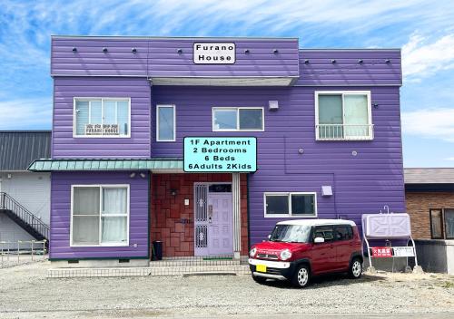 una casa viola con una macchina parcheggiata di fronte di Furano House, 1F Apartment, 2 Bedrooms, Max 8PP - 6 Adults 2 Kid, Near JR, Group Travel, Onsite Parking a Furano