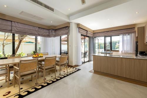 a kitchen and dining room with a table and chairs at Golden Cotton Villa 3BR Lagoon View by GRF in Laguna Phuket