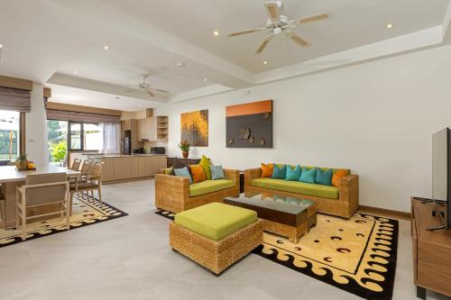 a living room with couches and a dining room at Golden Cotton Villa 3BR Lagoon View by GRF in Laguna Phuket