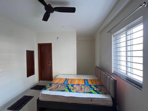 a bed in a room with a ceiling fan at Palani grand in Hyderabad