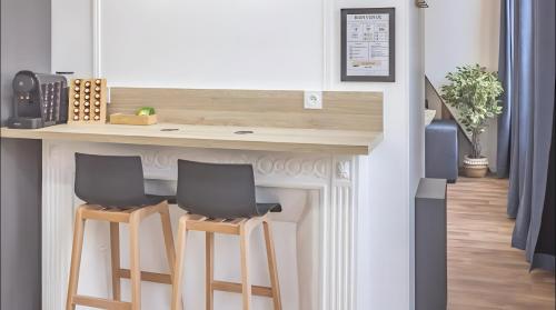 une cuisine avec un comptoir et deux tabourets de bar dans l'établissement Le Repaire des Templiers 6 pers, à Troyes