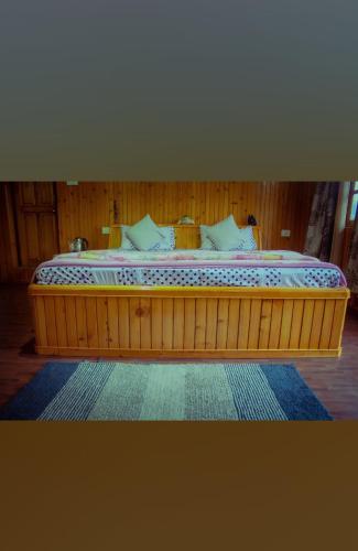 a large wooden bed in a room with at Miryok Homes in Mirik