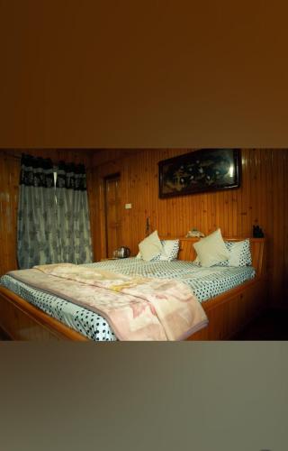 a bedroom with a large bed with white pillows at Miryok Homes in Mirik