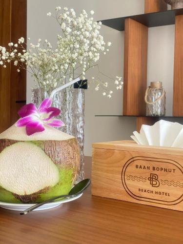 a bowl of fruit on a table with a vase with flowers at Baan Bophut Beach Hotel Samui - SHA Extra Plus in Bophut 