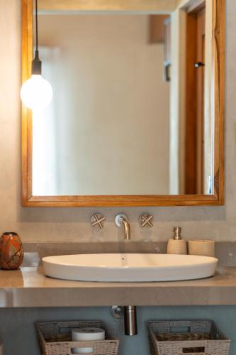 a bathroom sink with a large mirror above it at Suwa Villa Arenal in Fortuna