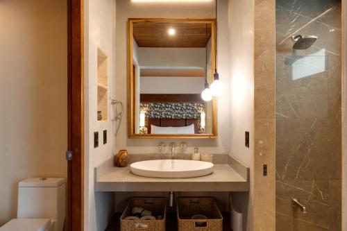 a bathroom with a sink and a mirror at Suwa Villa Arenal in Fortuna