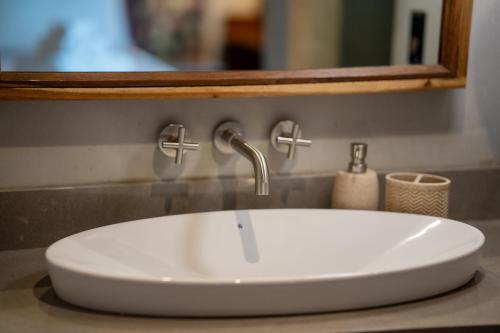 a white sink in a bathroom with a mirror at Suwa Villa Arenal in Fortuna