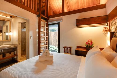 a bedroom with a white bed and a sink at Suwa Villa Arenal in Fortuna