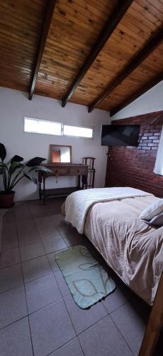 a bedroom with a bed and a desk in it at La Posada del Mainumby in Ituzaingó