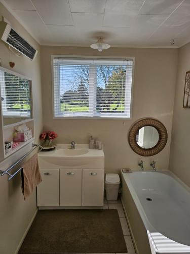 a bathroom with a sink and a tub and a toilet at On Tate in Waitara