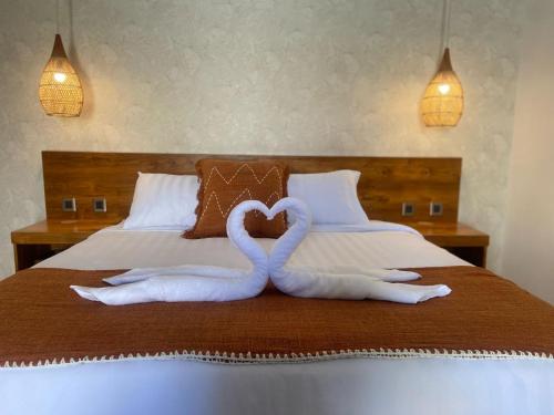 two swans making a heart on a bed at Santai Suites Nusa Dua in Nusa Dua