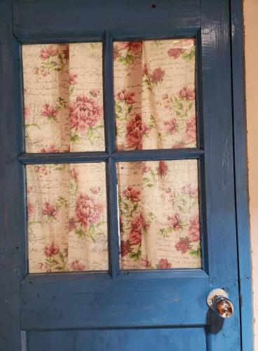 a blue door with a window with flowers on it at Eternal Seaside House in Nangan