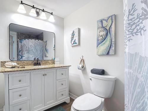 a bathroom with a toilet and a sink and a mirror at The Austin Pearl in Fort Myers Beach