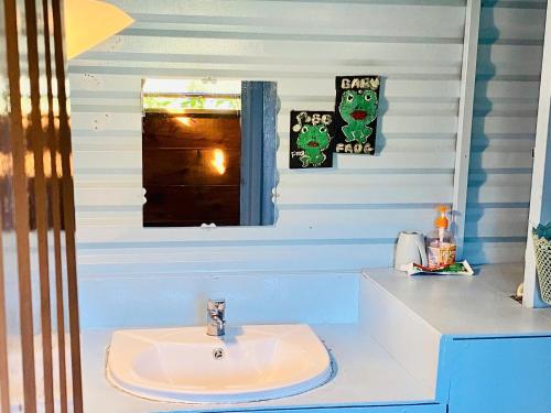 a bathroom with a sink and a window at Cú Trên Cây Homestay in Xuan An