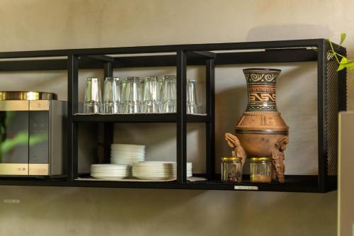 a black shelf with dishes and a vase on it at Suwa Villa Arenal in Fortuna