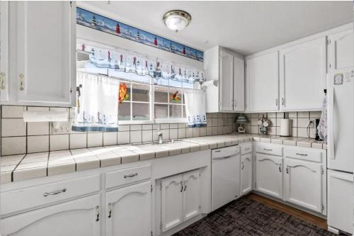 a white kitchen with white cabinets and windows at STR25-15 Private Room in Marina
