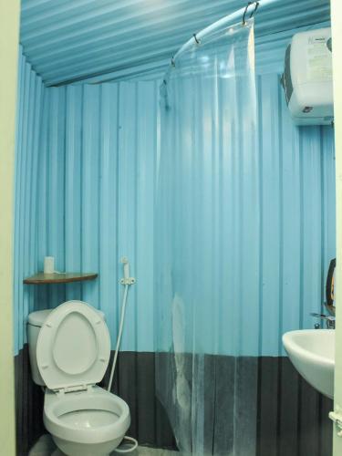a bathroom with a toilet and a sink at Cú Trên Cây Homestay in Xuan An