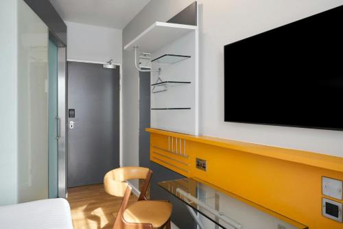 a living room with a tv and a chair at Four Points Flex by Sheraton Newcastle in Newcastle upon Tyne