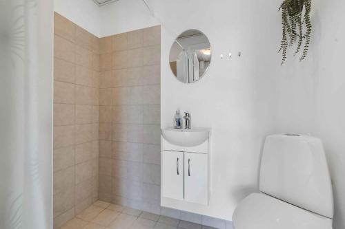 a white bathroom with a toilet and a sink at Holiday Home With Outdoor Jacuzzi And Shelter in Vig