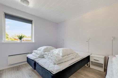 a bedroom with a bed with white sheets and a window at Holiday Home With Outdoor Jacuzzi And Shelter in Vig