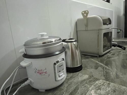 ディポログにあるSapayag Backpacker's Innのコーヒーメーカーの隣のカウンターに置かれたスロークッカー