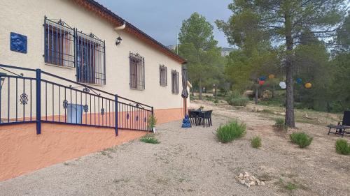 a house with a fence and a table in front of it at Casa Las Maletas in Morote