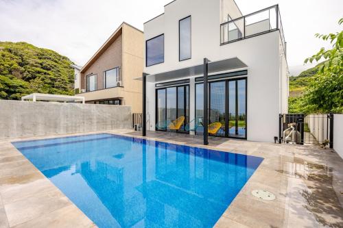 a swimming pool in front of a house at Gold Valley Villa A in Futtsu