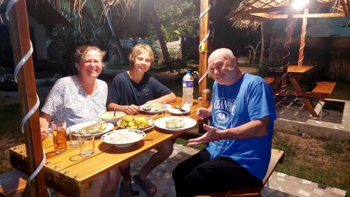 a group of people sitting at a table eating food at The Dream Inn Guesthouse Passikudah in Batticaloa