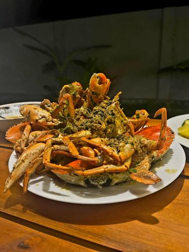 a plate of food on a wooden table at The Dream Inn Guesthouse Passikudah in Batticaloa